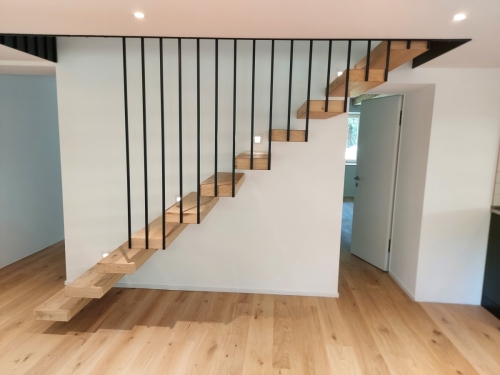 Escalier suspendu en métal et bois, garde-corps/paroi en métal et marches en parquet assemblé